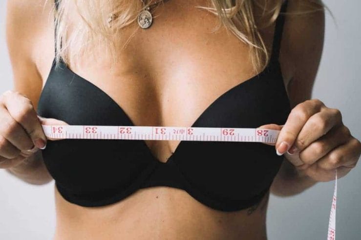 una donna si misura il seno con un centimetro